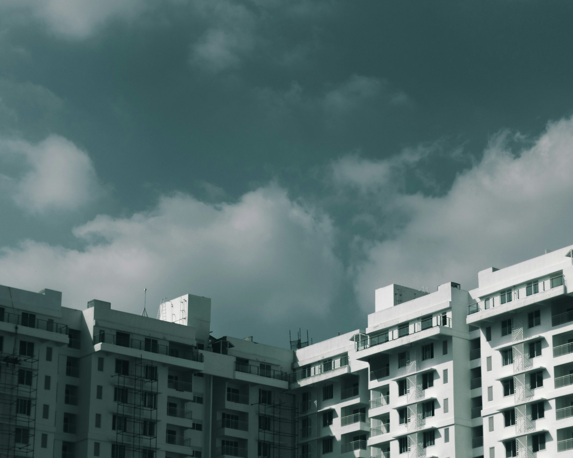 weißes Betongebäude unter bewölktem Himmel am Tag